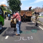 Perbaikan jalan Surabaya-Mojokerto di Desa Suwaluh yang sempat ditanami batang pisang, siang ini. foto: YUDI EP/ BANGSAONLINE