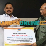 Bupati Gresik, Fandi Akhmad Yani, saat menerima bantuan dari Tenaga Ahli Kepala BNBP Pusat, Brigjen Bambang Eko. Foto: SYUHUD/BANGSAONLINE
