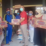 Ketua Gerindra Gresik dr. Asluchul Alif didampingi Bendahara Nur Saidah dan kader saat menyerahkan bantuan. foto: ist