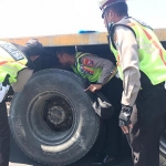 Polisi melakukan olah TKP di lokasi kejadian dan memeriksa truk yang melindas korban.