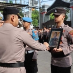 Kapolres Tulungagung, AKBP Arsya Khadafi saat memberikan tanda silang pada foto Aiptu Udi Cahyono dalam prosesi PTDH di mapolres setempat, Senin (1/4/2024). Foto: Dok. Humas Polres Tulungagung.