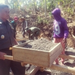 Kasdim 0818 Malang-Batu Mayor Inf Teguh turut mengangkat material bersama warga.