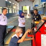 Kasi Pengujian Kendaraan Bermotor Dishub Kota Mojokerto Setiyo Budi Utomo (kiri) dan Kabid Angkutan Jalan Agus Tuti Rosyid memantau kalibrasi uji emisi di kantor dishub setempat. 