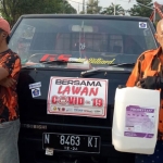 Gaib Sampurno (kanan) siap-siap berangkat untuk melakukan penyemprotan disinfektan.