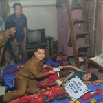 Bupati Mojokerto saat menyalurkan BLT DBHCHT ke salah satu penerima manfaat.