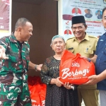 General Manager of CSR SIG, Edy Saraya (paling kanan) didampingi Kepala Kelurahan Singosari, Nastain (kedua kanan), menyerahkan bantuan paket sembako kepada Siti Aminah, warga Kelurahan Singosari. Foto: Ist