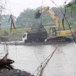Warga menunjukkan penampang pasir yang menggunakan alat berat di desa Bukur, Kecamatan Sumbergempol, Tulungagung. foto: feri/ BANGSAONLINE