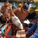 Bupati Sumenep Dr. KH. A. Busyro Karim saat memimpin pembagian sembako kepada ratusan Tukang Becak di Kecamatan Kalianget, Selasa (14/04/2020).
