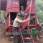 Petugas dari Polsek dan Koramil Wuluhan saat membongkar gubuk yang diduga digunakan sebagai tempat pengajaran aliran sesat. foto: PENDAM BRAWIJAYA