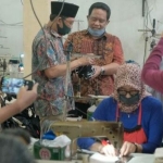Dion didampingi H Ridluwan meninjau UMKM pembuatan masker.