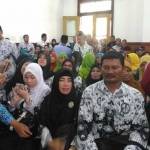 Terdakwa Muhammad Samhudi (tengah) diapit dan diajak foto oleh para guru PGRI Sidoarjo, saat hendak duduk di kursi pesakitan PN Sidoarjo untuk menjalani persidangan. foto: NANANG I/ BANGSAONLINE