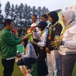 Bupati Lamongan Yuhronur Efendi (kiri) mengalungkan medali kepada atlet sepak bola putri Lamongan. Foto: Ist.
