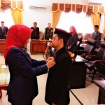 Febriyana Meldyawati memasang emblem DPRD kepada Miftah Aris dalam sidang Paripurna PAW. foto: YUDI EKO PURNOMO/BANGSAONLINE 