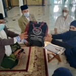 Santy Meilansari menerima cinderamata dari Dr. KH. M. Sujak usai ikrar dua kalimat syahadat di Masjid Nasional Al-Akbar Surabaya usai salat Jumat (15/1/2021). foto: mma/ BANGSAONLINE.com