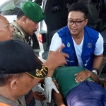 Kopda Soleh bersama petugas medis kecamatan dibantu warga, sedang mengangkat korban masuk ke dalam mobil ambulans.