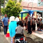 Aparat polisi saat menjaga kepulangan anak sekolah.