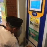 Salah satu warga saat mencoba mengambil beras di mesin ATM di Masjid Al-Khalid Kelurahan Semampir, Kota Kediri.