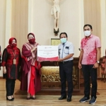 Direktur Risiko Bisnis Bank Jatim Rizyana Mirda menganugerahkan bantuan kepada Ketua Panitia Pembangunan Gereja Theofillus Banu Dwi, disaksikan oleh Wakil Ketua Komisi C DPRD Provinsi Jawa Timur, Yohanes Ristu Nugroho. foto: istimewa