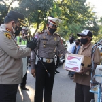 Kapolres Kediri Kota AKBP Wahyudi (kiri) didampingi Kasatlantas AKP Arpan saat menyerahkan bantuan paket sembako kepada salah satu tukang becak. foto: ist.