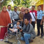 Kalapas Klas II Pamekasan, Hanafi, foto bersama Agam usai memberikan bantuan kursi roda.