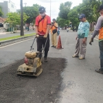 Petugas dari Dinas PUCKPP Banyuwangi saat memperbaiki jalan berlubang.