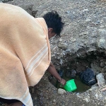 Salah satu warga dari Kecamatan Robatal, Sampang, saat menampung air keruh di pinggir sungai. Foto: Ist