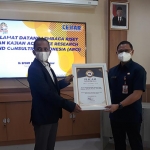 CEO ARCI Baihaki Siradj menyerahkan piagam penghargaan OPD Peduli Covid-19 di Jawa Timur kepada Kepala BPSDM Jatim Aries Agung Paewai. (foto: DIDI ROSADI/ BANGSAONLINE)