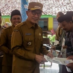 Bupati Pamekasan saat menyerahkan sertifikat dari program PTSL di Kelurahan Gladak Anyar.