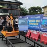 Salah satu warga saat mencoba alat peraga Safety Belt Reminder. (Ist)