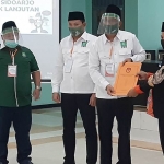 KPU Sidoarjo menyerahkan tanda terima pendaftaran ke Ahmad Muhdlor-Subandi, Minggu (6/9) malam. foto: MUSTAIN/ BANGSAONLINE