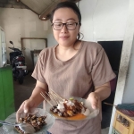 Endang saat hendak menghidangkan sate dan krengsengan bekicot kepada pelanggannya. Foto: MUJI HARJITA/ BANGSAONLINE