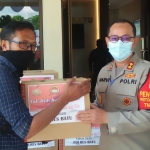 Kapolres Batu AKBP Harviadhi Agung Prathama saat menyerahkan paket sembako kepada salah satu awak media Pokja Polres Batu, Selasa (30/6).