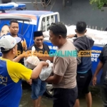 Sekretaris DPD NasDem Gresik, Ainul Fuad, saat memberi bantuan kepada korban banjir di Desa Jono, Kecamatan Cerme. Foto: SYUHUD/BANGSAONLINE