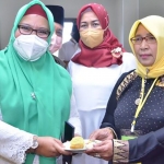 Wabup Gresik, Bu Min, didampingi Bendahara DPC PDIP Gresik Siti Muafiyah saat memberikan potongan tumpeng di acara peringatan Maulidur Rosul. Foto: SYUHUD/ BANGSAONLINE