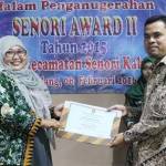 Camat Senori, Eko Julianto saat memberikan penghargaan terbaik bidang administrasi pelayanan publik kepada Kepala Desa Wanglu Wetan. foto: suwandi/ BANGSAONLINE
