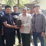 Ketua KPU Kota Batu Mardiono secara simbolis menyerahkan bibit pohon kepada Kepala Desa Tlekung, Mardi.