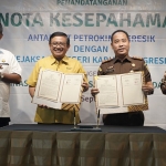 Dirut Petrokimia Gresik, Dwi Satriyo Annurogo, bersama Kajari Gresik, M Hamdan Saragih, disaksikan Bupati Gresik, Fandi Akhmad Yani, saat menunjukkan MoU yang telah ditandatangani. Foto: Ist