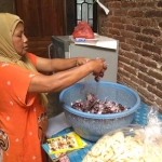 Siti Khotijah saat mengemas madu mongso dan arak keling, jajanan hasil olahan tangannya.