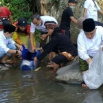 Prof. Dr. KH. Asep Saifuddin Chalim, M.A. dan Muhammad Al-Barra (Gus Bara) saat melepas ikan di sungai Desa Pacet Mojokerto, Sabtu (5/6/2021). foto: mma/ bangsaonline.com