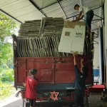 Petugas saat menurunkan bilik suara dari atas truk.