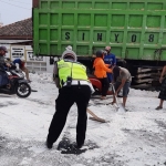 Petugas dibantu warga membersihkan pedel yang memenuhi badan jalan.