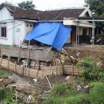 RENTAN: Kondisi rumah Misnan yang menggantung di tepi sungai lantaran plengsengan sungai terus digerus air. foto: gunadhi/ BANGSAONLINE
