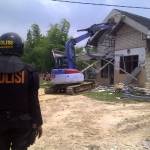 Salah satu rumah keluarga tergugat dihancurkan dengan alat berat begho saat eksekusi lahan di Desa Pagagan, Pademawu, Pamekasan, Senin (10/3). Foto: Rizal