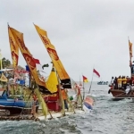 Para nelayan saat melarung sesaji ke laut.