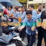 Karyawan Tjiwi Kimia saat membagikan takjil ke masyarakat. Foto: MUSTAIN/BANGSAONLINE
