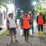 Tim gabungan saat melakukan penyemprotan disinfektan untuk menenangkan warga.