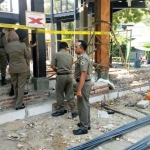 Petugas saat memasang garis tanda segel di bangunan milik Sudarmi di GKB. foto: SYUHUD/ BANGSAONLINE