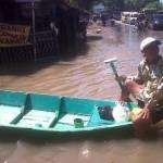Husein, kakek yang memanfaatkan bencana banjir sebagai lahan untuk mengeruk rupiah. foto: detik.com