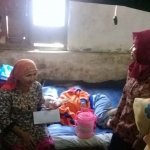 Fatimah (tengah) terbaring di kasur didampingi neneknya saat mendapatkan bantuan swadaya.