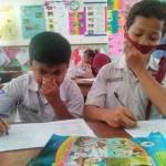 Siswa belajar sambil menutup hidungnya karena tak kuat atas bau yang menyengat. foto: DEVI/ BANGSAONLINE